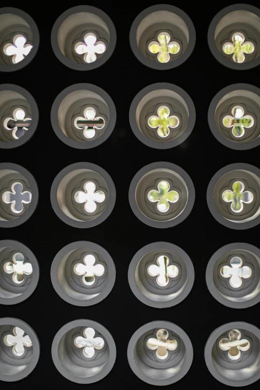 a bunch of buttons sitting on top of a table, inspired by Bruce Munro, unsplash, generative art, clover, sunken recessed indented spots, window lighting, plant patterns