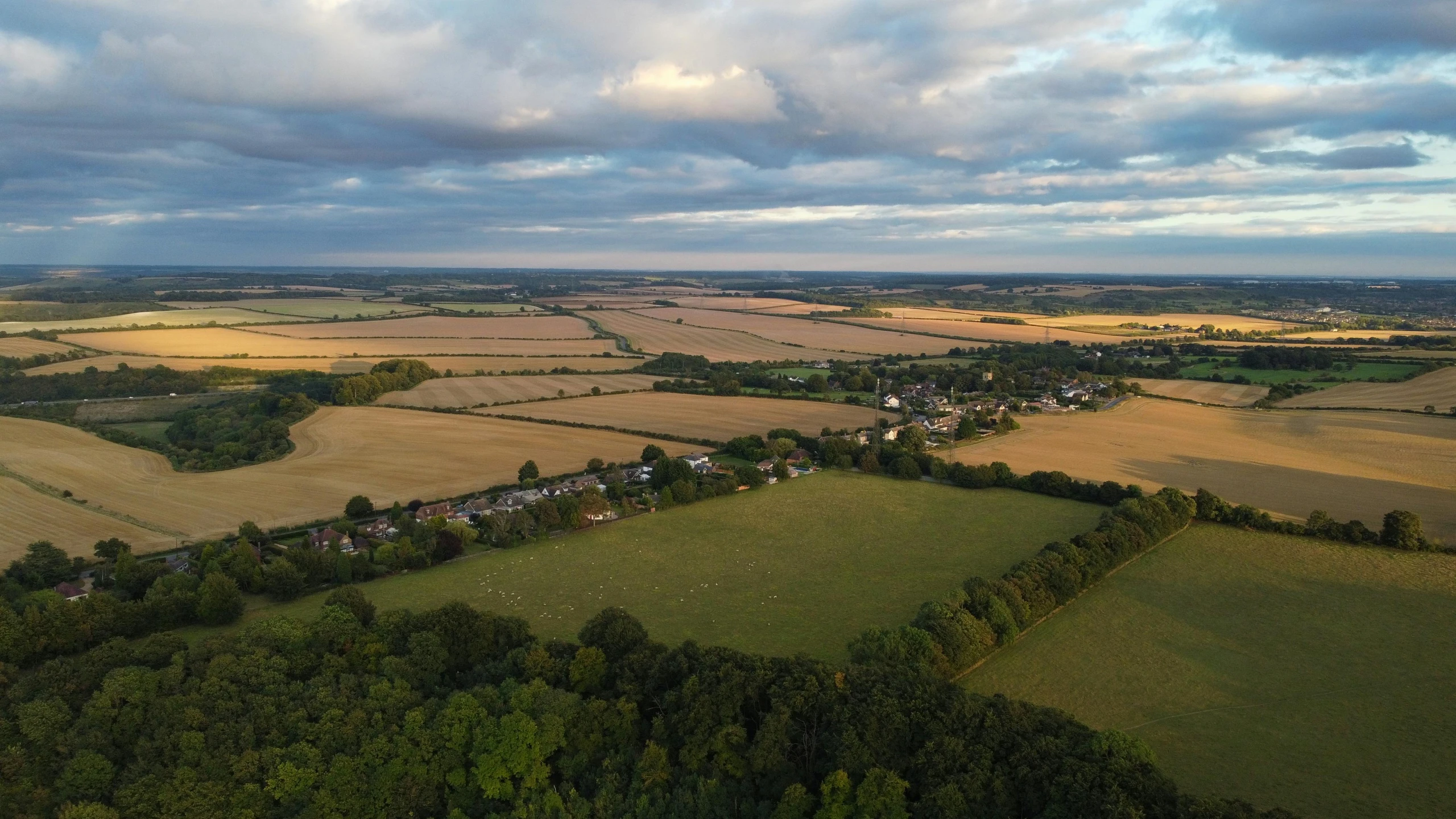 an overhead view of farm fields and green fields with houses