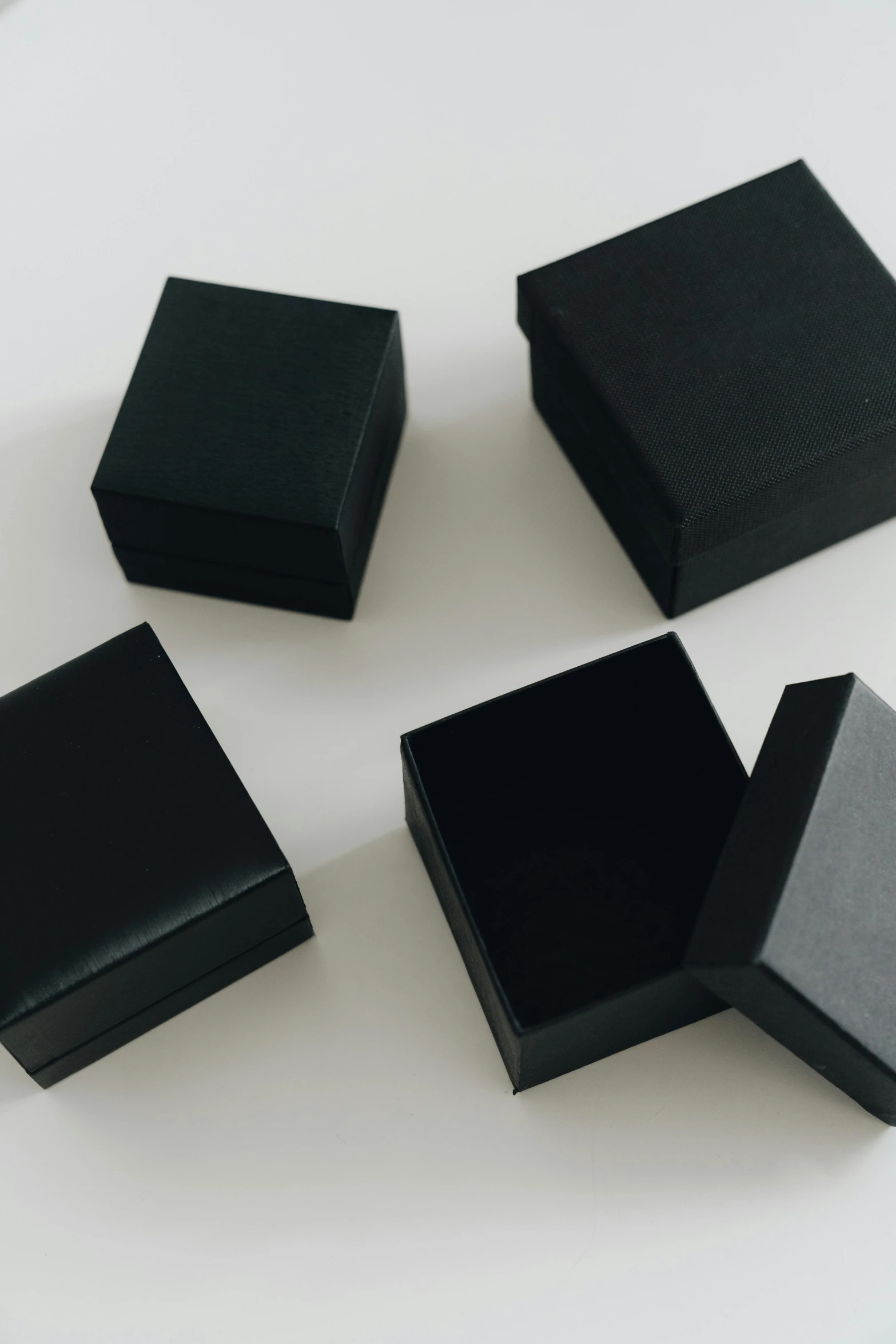 a group of black boxes sitting on top of a table, trending on unsplash, square, jewelry, made of rubber, box