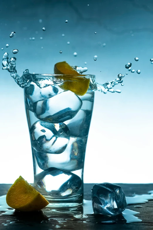 an ice cold water splashes out from inside a glass