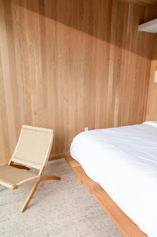 a bedroom with wood paneling and a bed