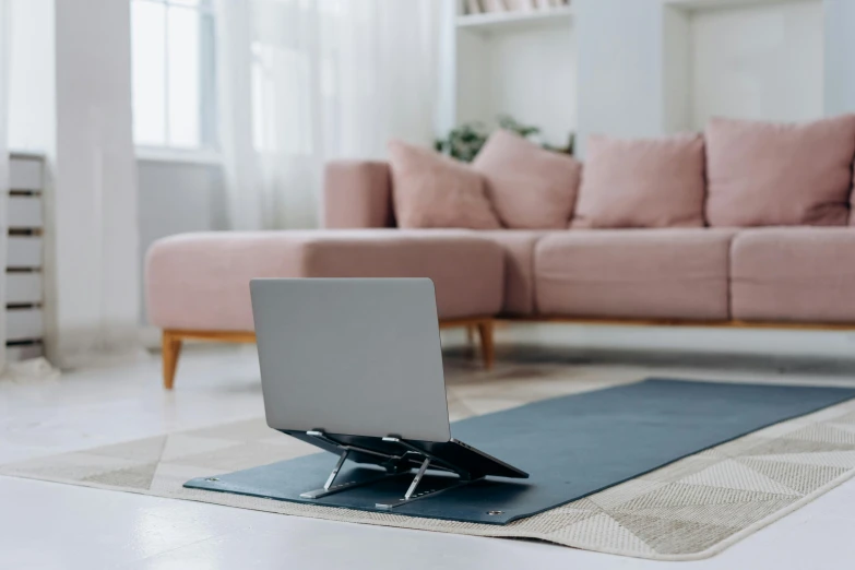 a laptop computer sitting on top of a yoga mat, private press, placed in a large living room, slate, product view, lepra