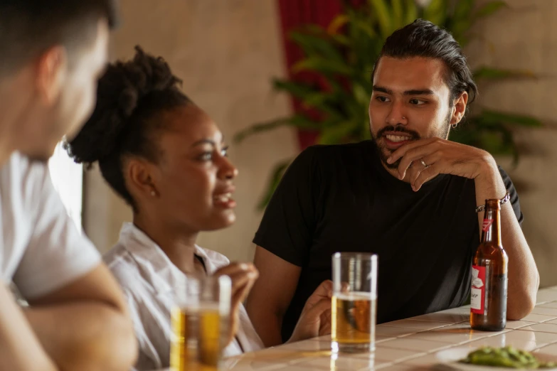 a group of people sitting at a table with drinks, profile image, intense flirting, black man, zoomed in