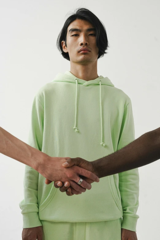 two men shaking hands in front of a white background, a colorized photo, inspired by Luigi Kasimir, trending on unsplash, black haired girl wearing hoodie, gradient pastel green, ignant, sad men