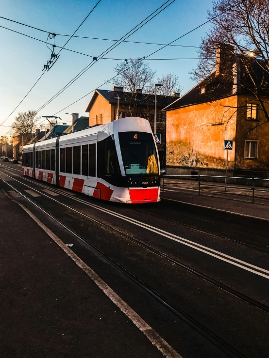 a train moving along a road next to a building