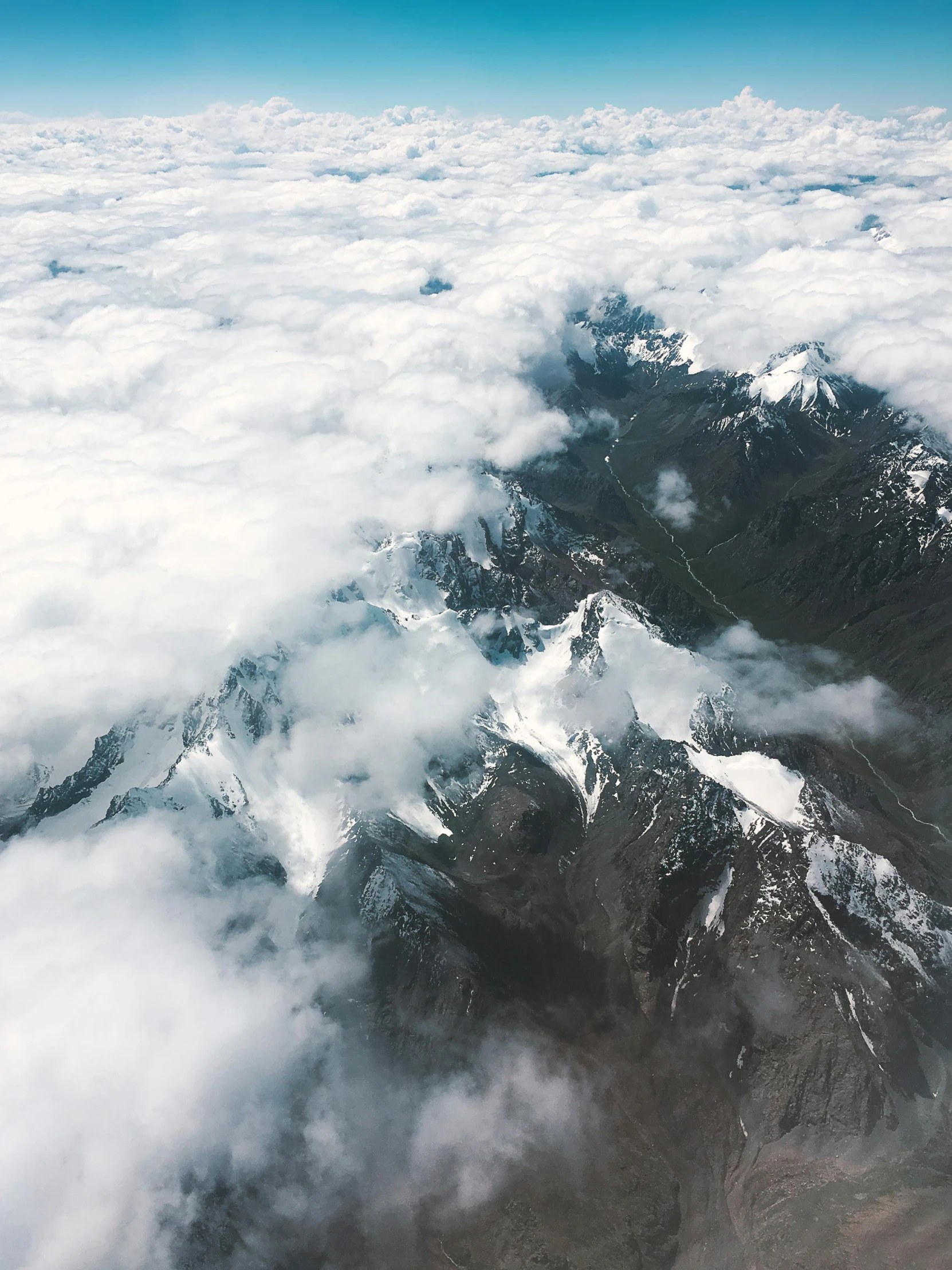 the top of mountains are covered in clouds