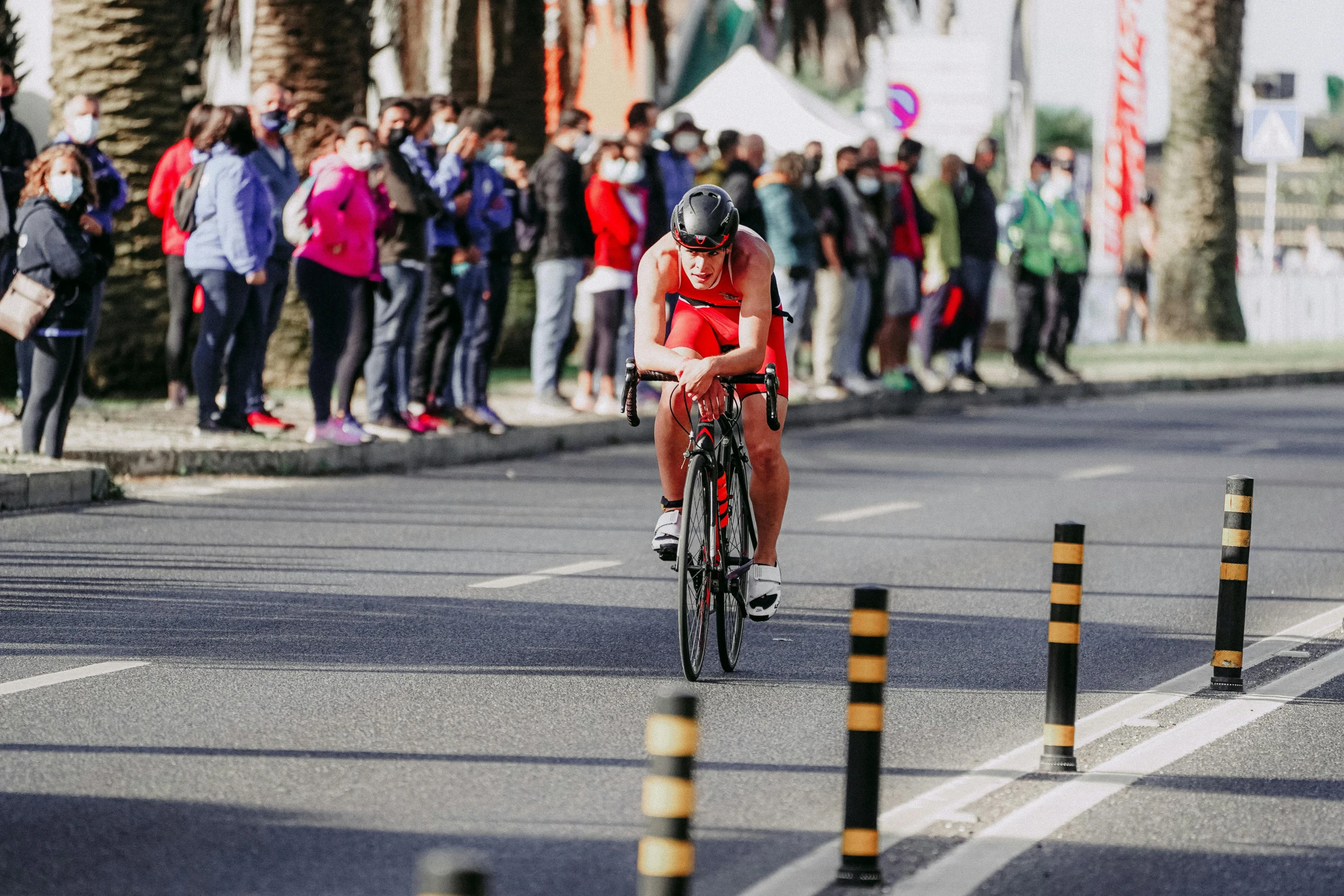 a man riding a bike down a street next to a crowd of people, pexels contest winner, ironman, sprinters in a race, thumbnail, 8k octan photo