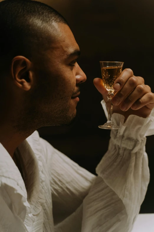 a man is holding a glass with some wine