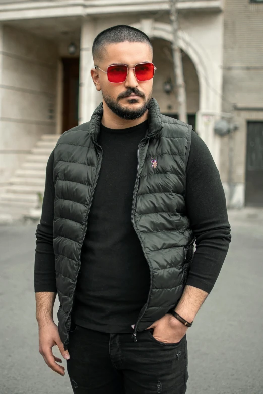 a man wearing sunglasses standing in front of a building, black vest, moncler jacket, turkish and russian, profile image