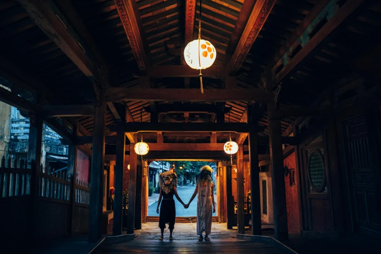 two women holding hands outside a wooden building