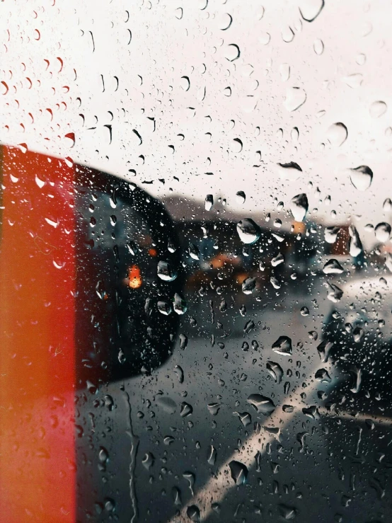 a close up of a window with rain on it, a picture, trending on unsplash, inside of a car, vibrant but dreary orange, album cover, view from a news truck