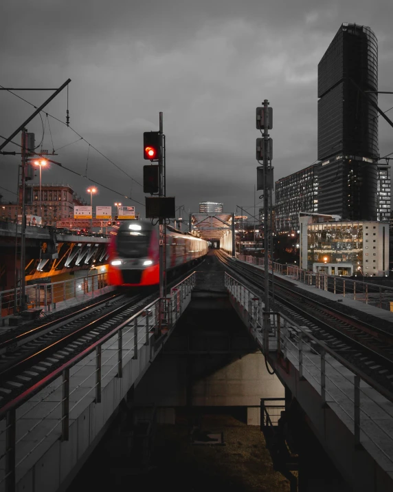 a train traveling through a city next to tall buildings, ominous lighting, non-binary, moscow metro, #trending