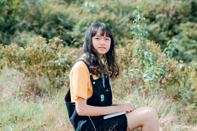 a girl sitting on a rock in a field, by Tan Ting-pho, unsplash, realism, seifuku, portrait image, yellow hue, black