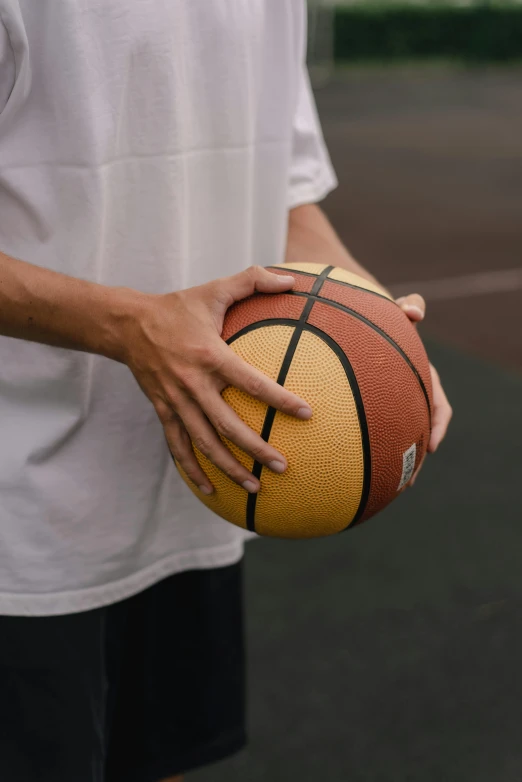 a person is holding a basketball in their hands