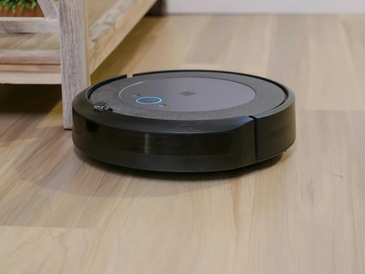 a black robot sitting on top of a wooden floor