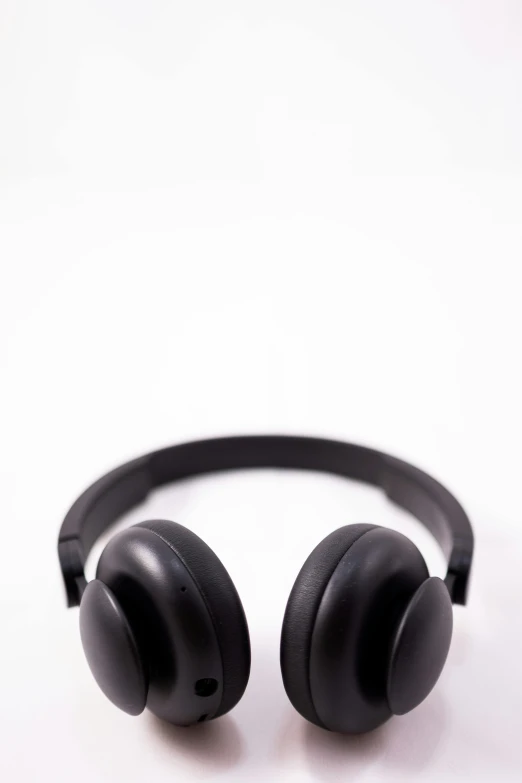 a pair of black headphones on a white surface, by Gavin Hamilton, pexels, made of rubber, stock photograph, front facing, 0 0 0