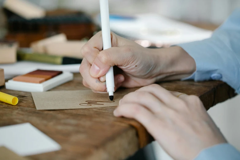 a person working on an object with their hand on a small paper