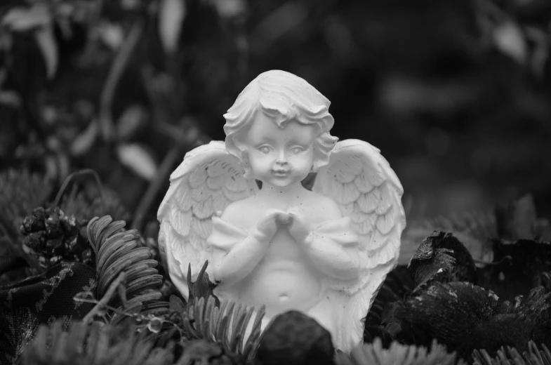 a statue of an angel in a garden, by Marie Angel, pixabay contest winner, icon black and white, miniature porcelain model, kewpie, prayer hands