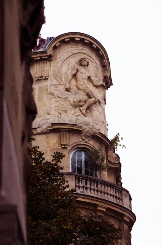 a clock that is on the side of a building, a statue, inspired by Alexandre Falguière, very detailed curve, view from a distance, taken in 1 9 9 7, carved into the side of a tree