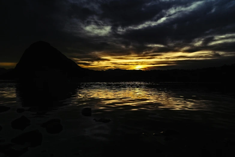 the sun is setting over a body of water, by Jan Tengnagel, pexels contest winner, hurufiyya, dark shadowy surroundings, gold glow, grey, black