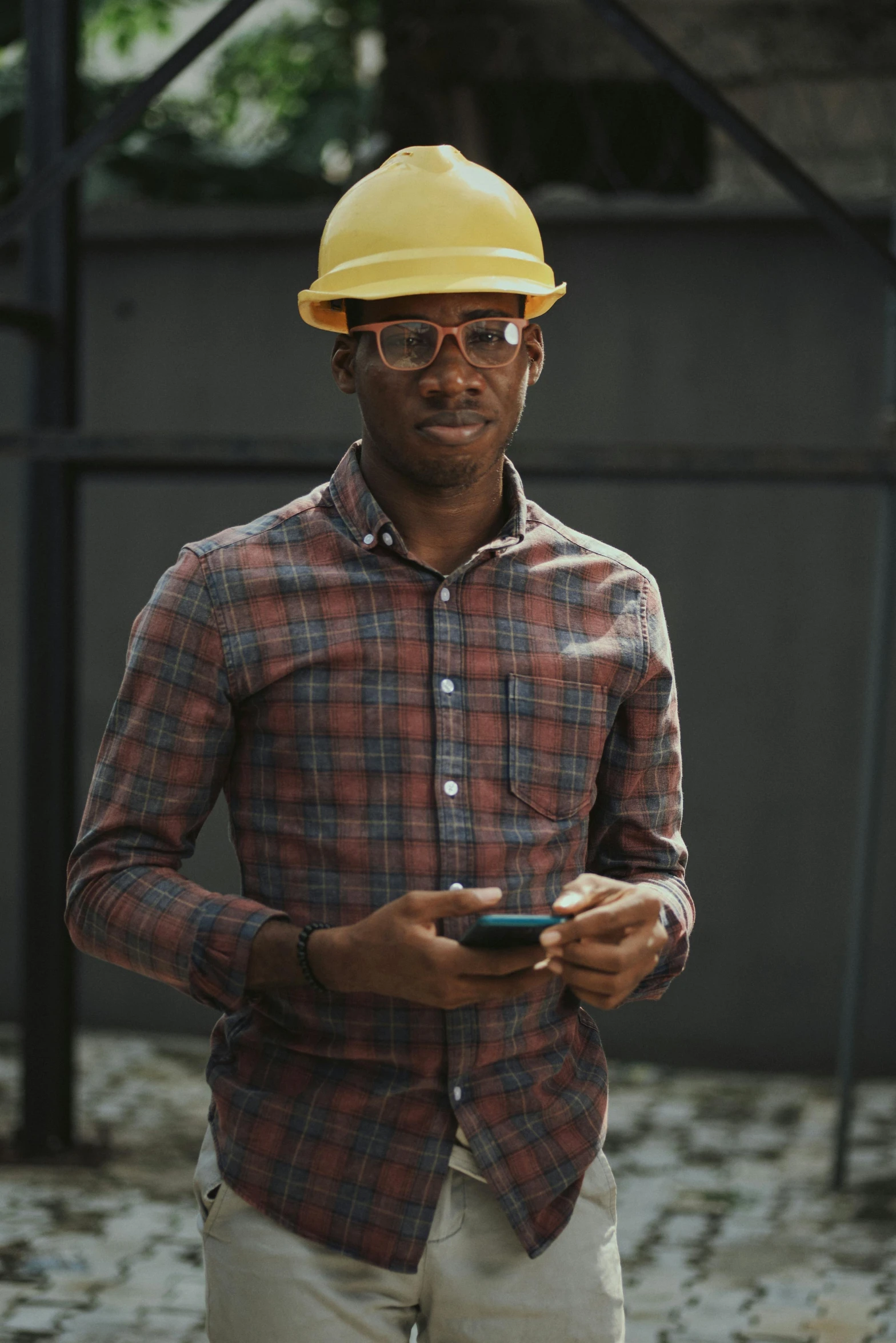 a man in a hard hat holding a cell phone, a portrait, by Chinwe Chukwuogo-Roy, pexels contest winner, hipster dad, lgbtq, worksafe. instagram photo, well - dressed