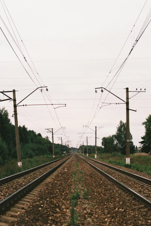 a train track surrounded by trees and power lines, by Anna Haifisch, unsplash, postminimalism, in russia, low quality photo, early 2 0 0 0 s, pov photo