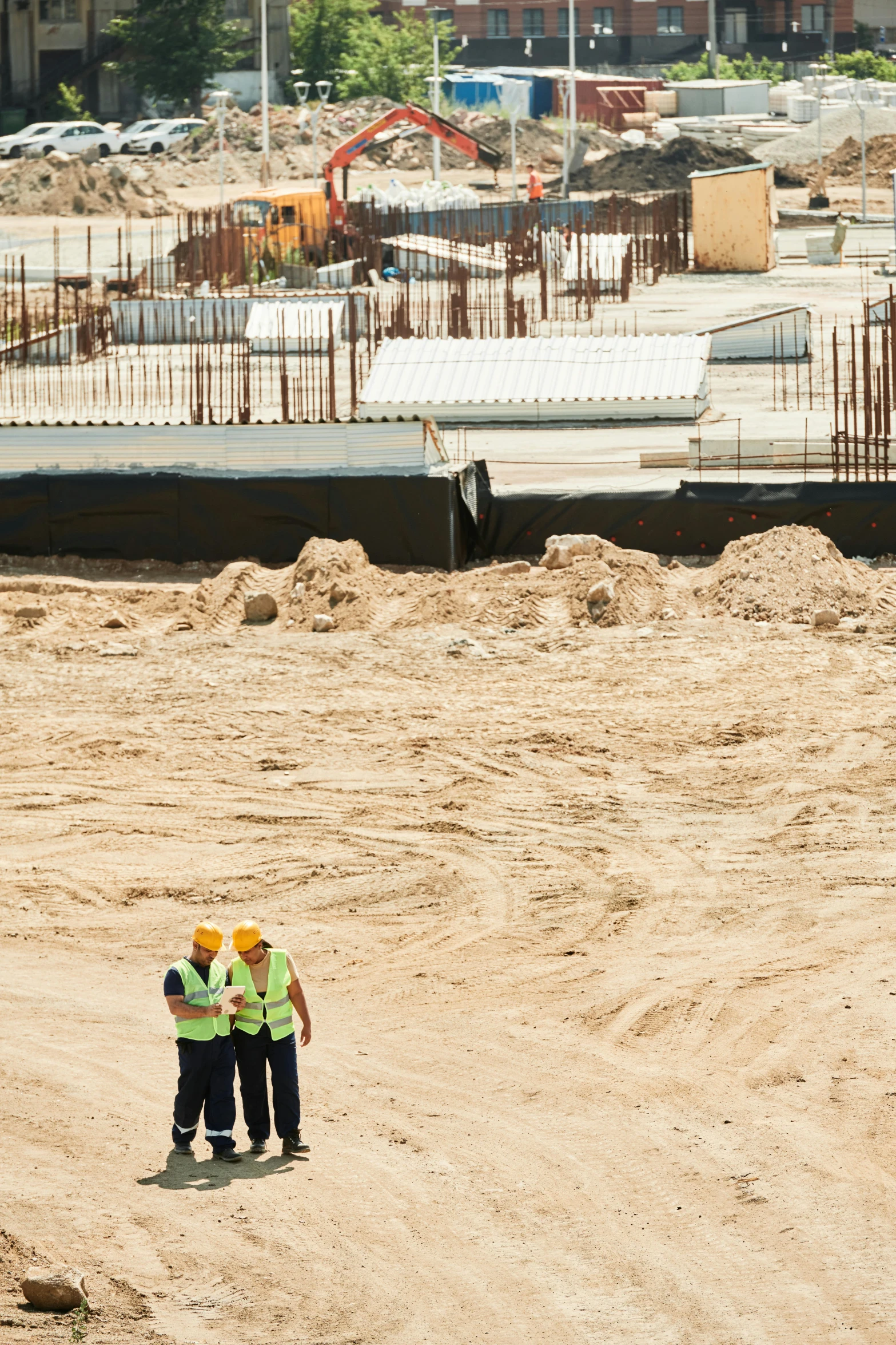 a couple of men standing on top of a dirt field, by Israel Tsvaygenbaum, unsplash, conceptual art, construction site, oman, subsiding floodwaters, in an arena pit