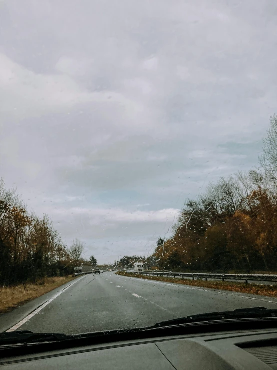 a car driving down a highway on a cloudy day, an album cover, unsplash, late autumn, trip to legnica, low quality photo, thumbnail