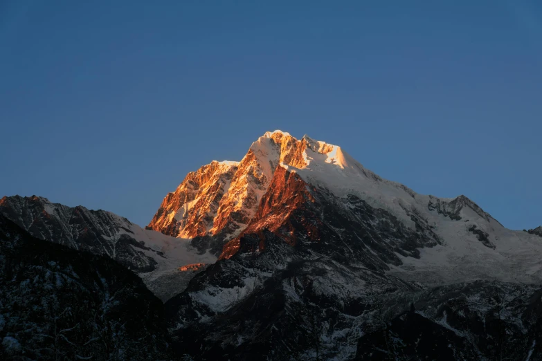 a mountain with some snow on it under a blue sky