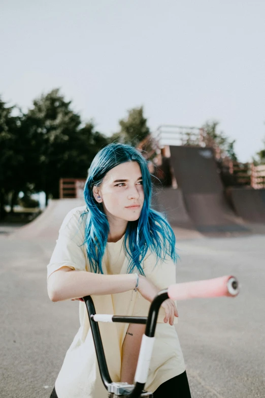 a woman with blue hair sitting on a scooter, inspired by Elsa Bleda, trending on pexels, at a skate park, headshot profile picture, concerned, bench
