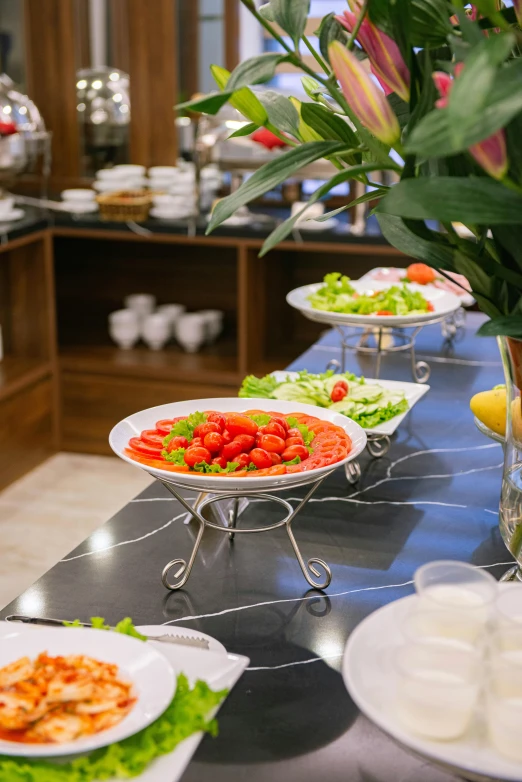 several plates of salads and side dishes on a bar