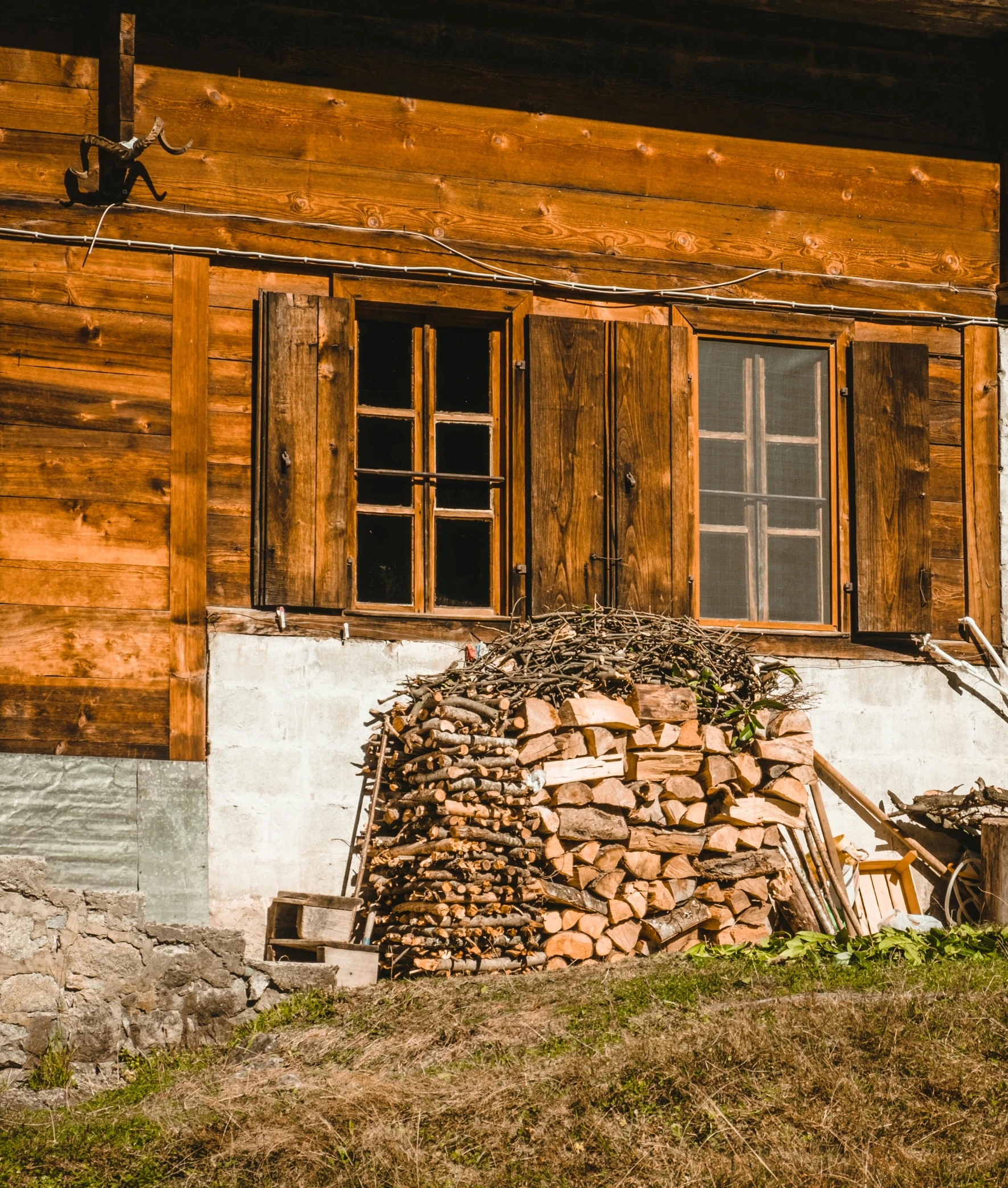 a horse standing next to a pile of wood, by Sebastian Spreng, pexels contest winner, renaissance, alpine architecture, fire from some windows, in front of the house, panoramic