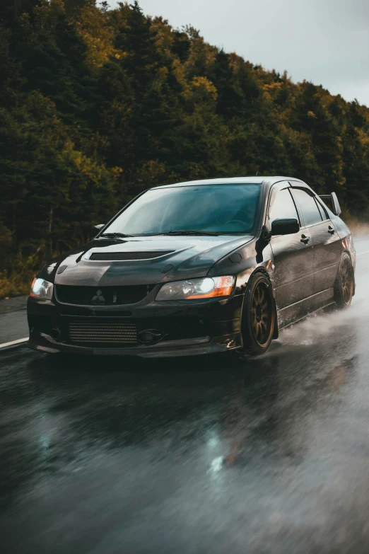 the car is driving down the wet road