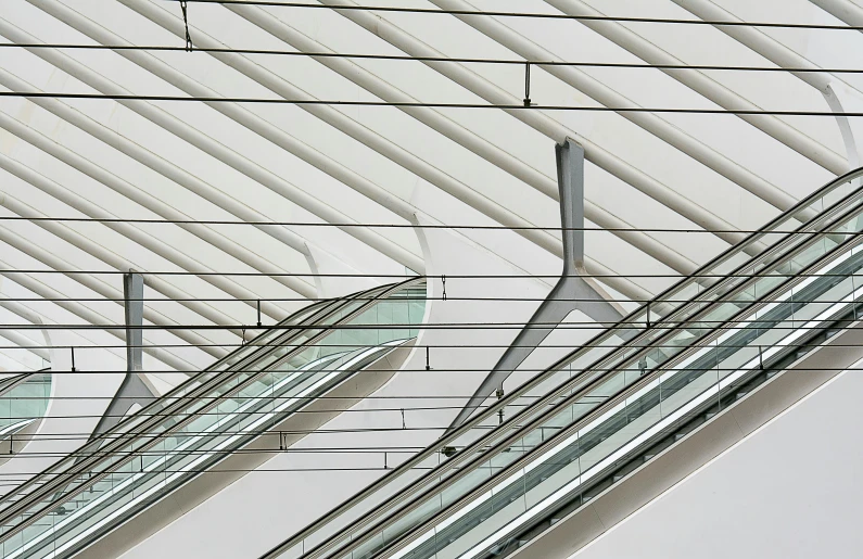 a couple of escalators sitting next to each other, an abstract sculpture, inspired by Zaha Hadid, pexels contest winner, light and space, overhead wires, abstract detail, square lines, angular minimalism