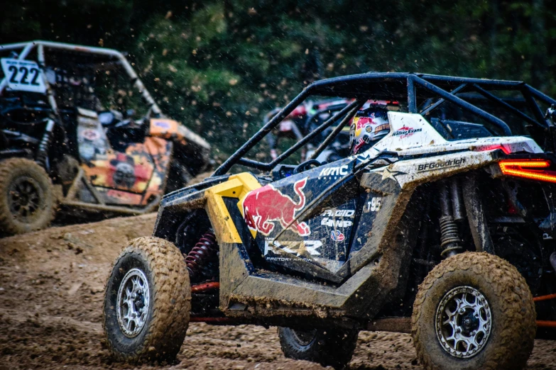 two atv racing cars are in the mud