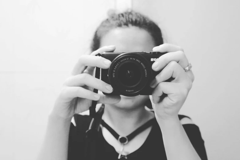 a woman taking a picture of herself with a camera, a black and white photo, head in frame, low quality photograph, # myportfolio, cute photograph