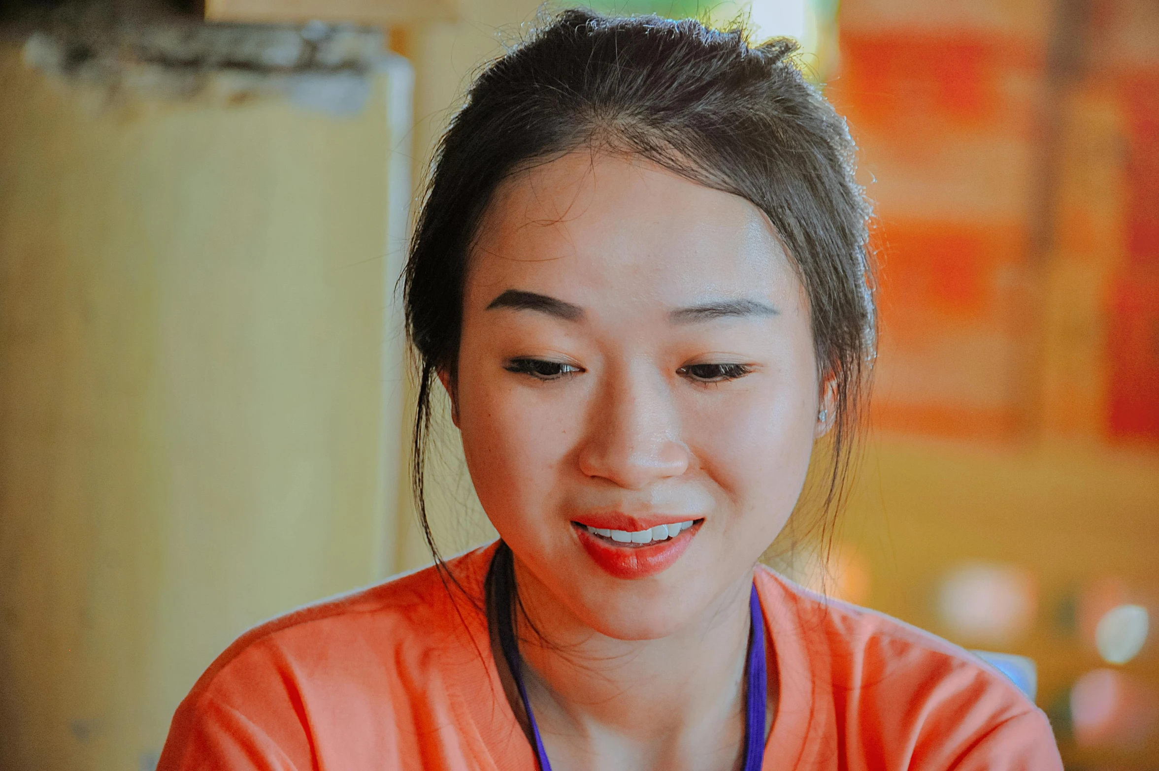 a woman sitting at a table with a plate of food, korean face features, orange hue, phong shaded, dimples