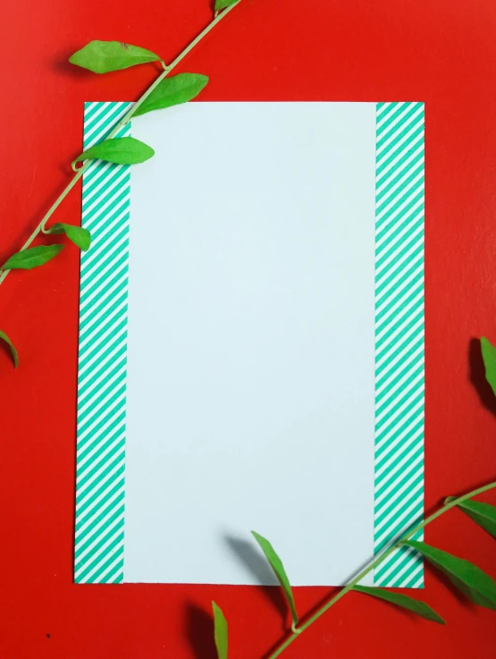 a white sheet of paper with green leaves on a red background, inspired by Barnett Newman, pexels contest winner, op art, teal lights, striped, clipboard, santa