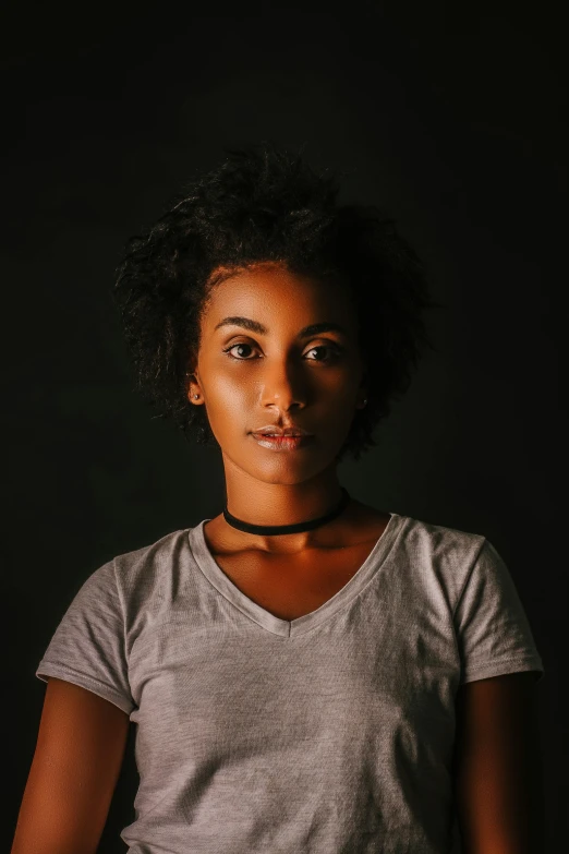 a woman standing in front of a black background, by Afewerk Tekle, pexels contest winner, halfbody headshot, ashteroth, teenage girl, light and dark