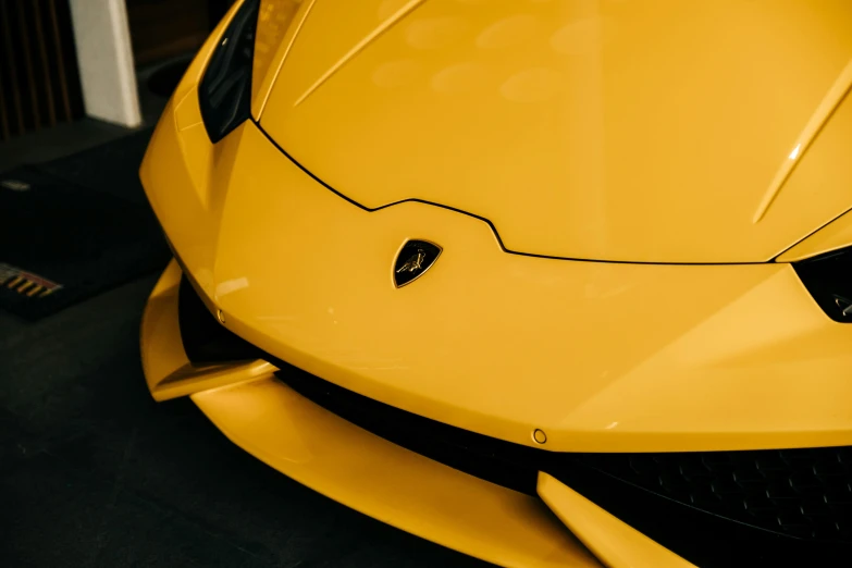 close up view of the hood and hood scoops on a yellow sports car