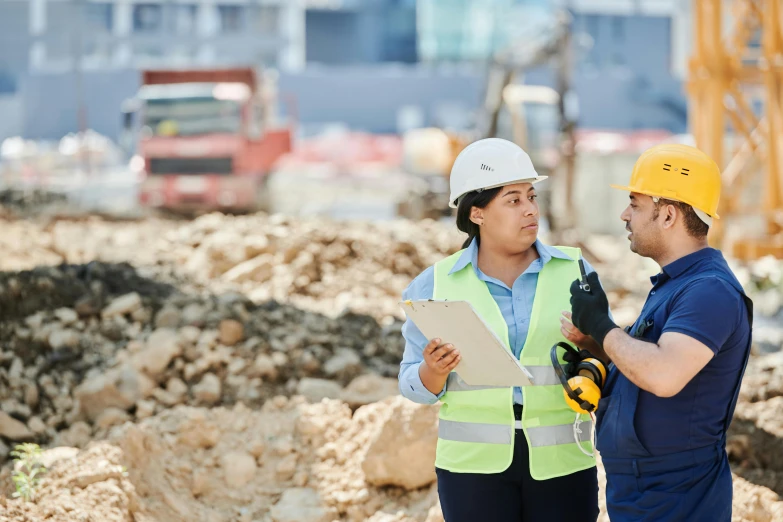 a couple of men standing next to each other on a construction site, a photo, shutterstock, male and female, australian, thumbnail, geology