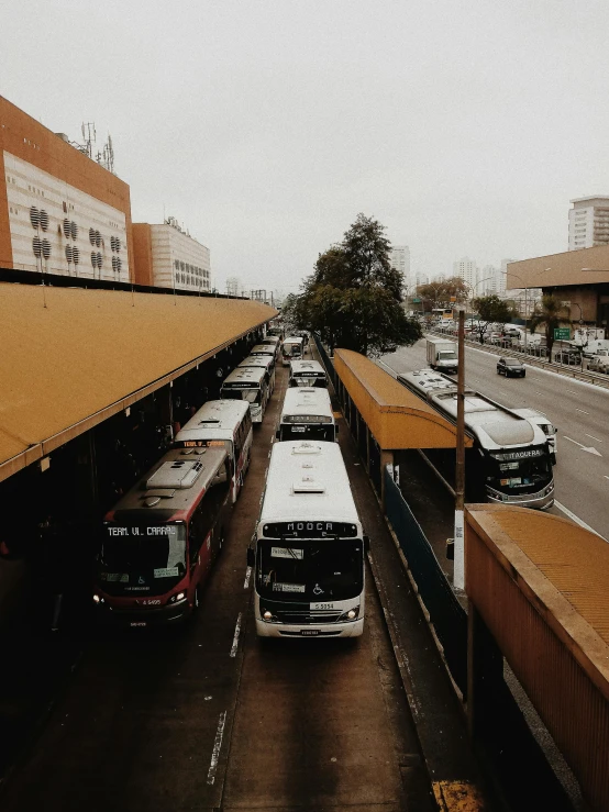 a group of buses parked next to each other on a street, overpass, trending on vsco, central station in sydney, 🚿🗝📝