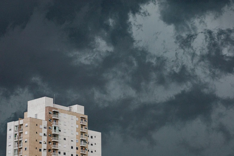 tall building standing with black clouds in the background