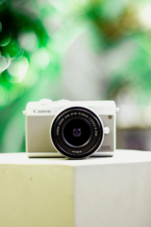 a white camera sitting on top of a table, a picture, by Robbie Trevino, canon 2 0 mm lens, 🎀 🍓 🧚, mini, front facing camera