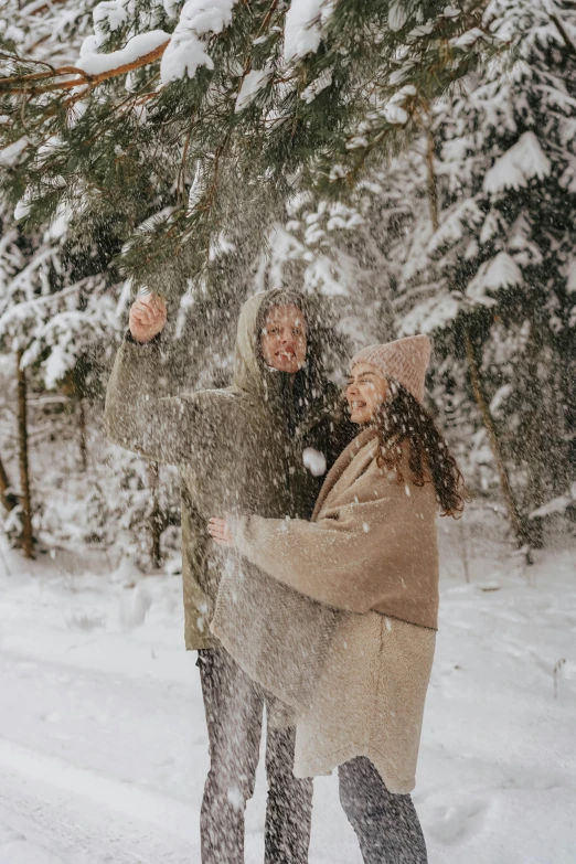 a couple hugging in the snow with one arm outstretched