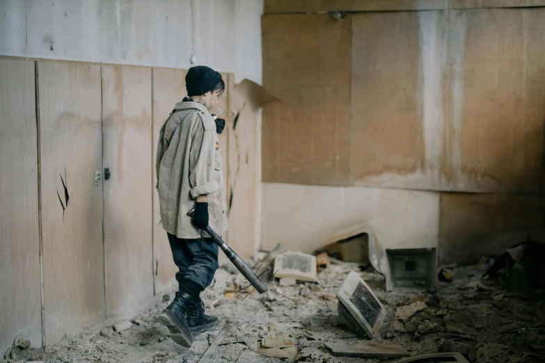 a man standing next to a pile of rubble, by Emma Andijewska, post apocalyptic room interior, holding spear, high quality photo, cleaning future