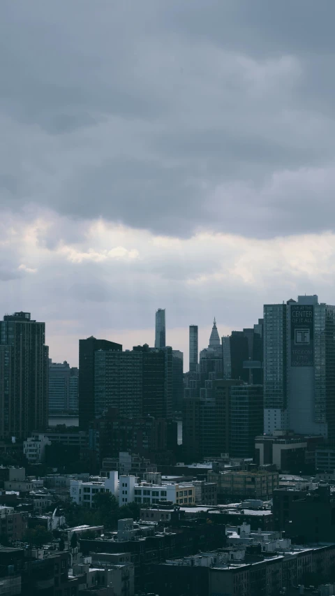 a view of a city from the top of a building, inspired by Elsa Bleda, unsplash contest winner, tonalism, gray clouds, new york skyline, low quality photo, cinematic establishing shot