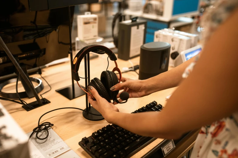 a woman sitting at a desk with headphones on, unsplash, hyperdetailed samsung store, “ iron bark, inspect in inventory image, closeup - view