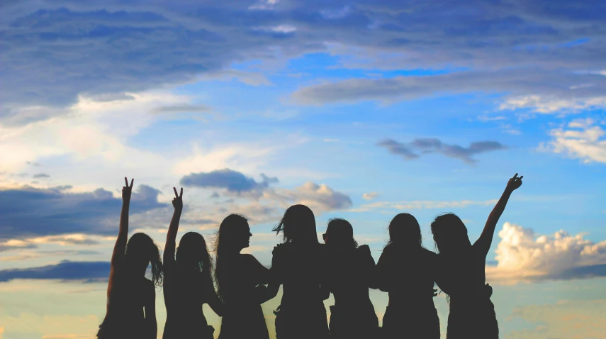 a group of women standing on top of a beach, by Caroline Mytinger, pexels contest winner, silhouette :7, long hairs, college girls, background image