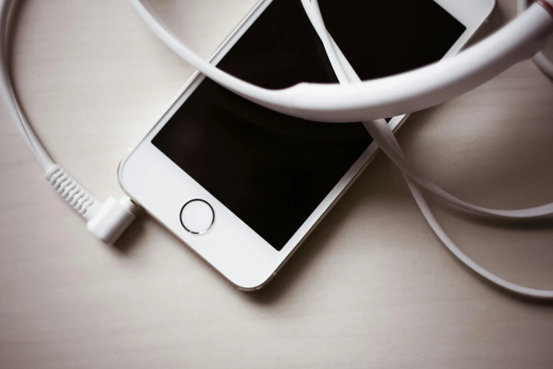 a close up of a cell phone connected to a charger, trending on pexels, square, headset, white hue, professional iphone photo